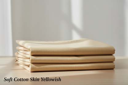 Create a 100% realistic vertical image showing skin Yellowish men’s unstitched cotton suit placed on a table in a neatly folded form. The fabric texture should be clearly visible with soft natural lighting. Keep the background simple and clean. Add the text ‘Soft Cotton Skin Yellowish’ at the bottom-left corner in a minimal, elegant font in black color